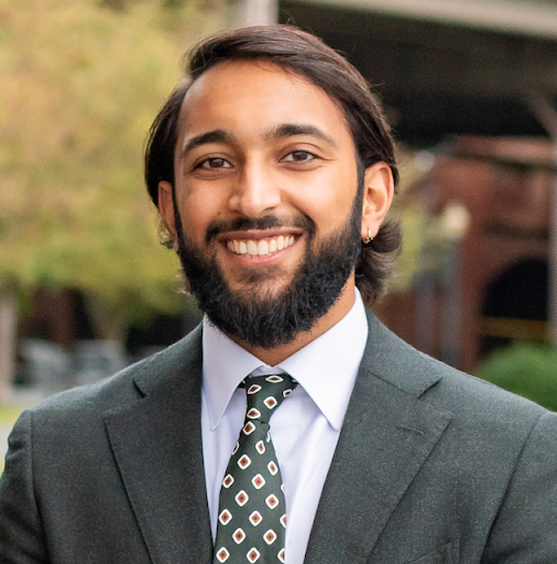 Chiraag Gohel headshot in a olive suit
