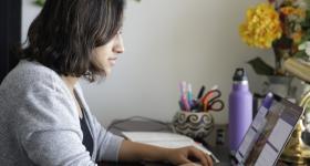 Student writing on a laptop